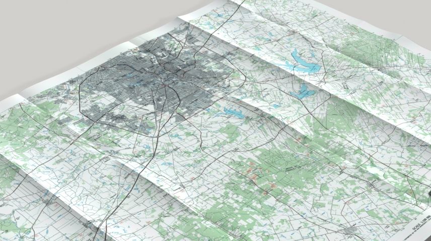 small glass models of 18-wheelers, trucks, and cars, drive across a physical paper map